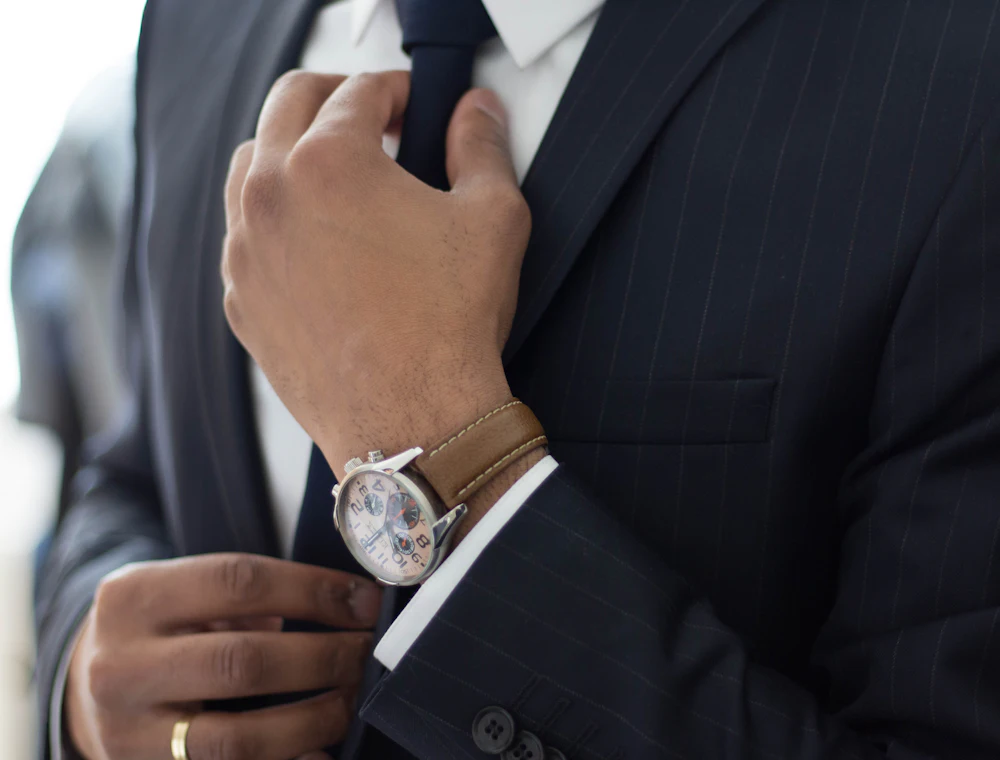 Abogado de traje azul ajustándose la corbata antes de una audiencia